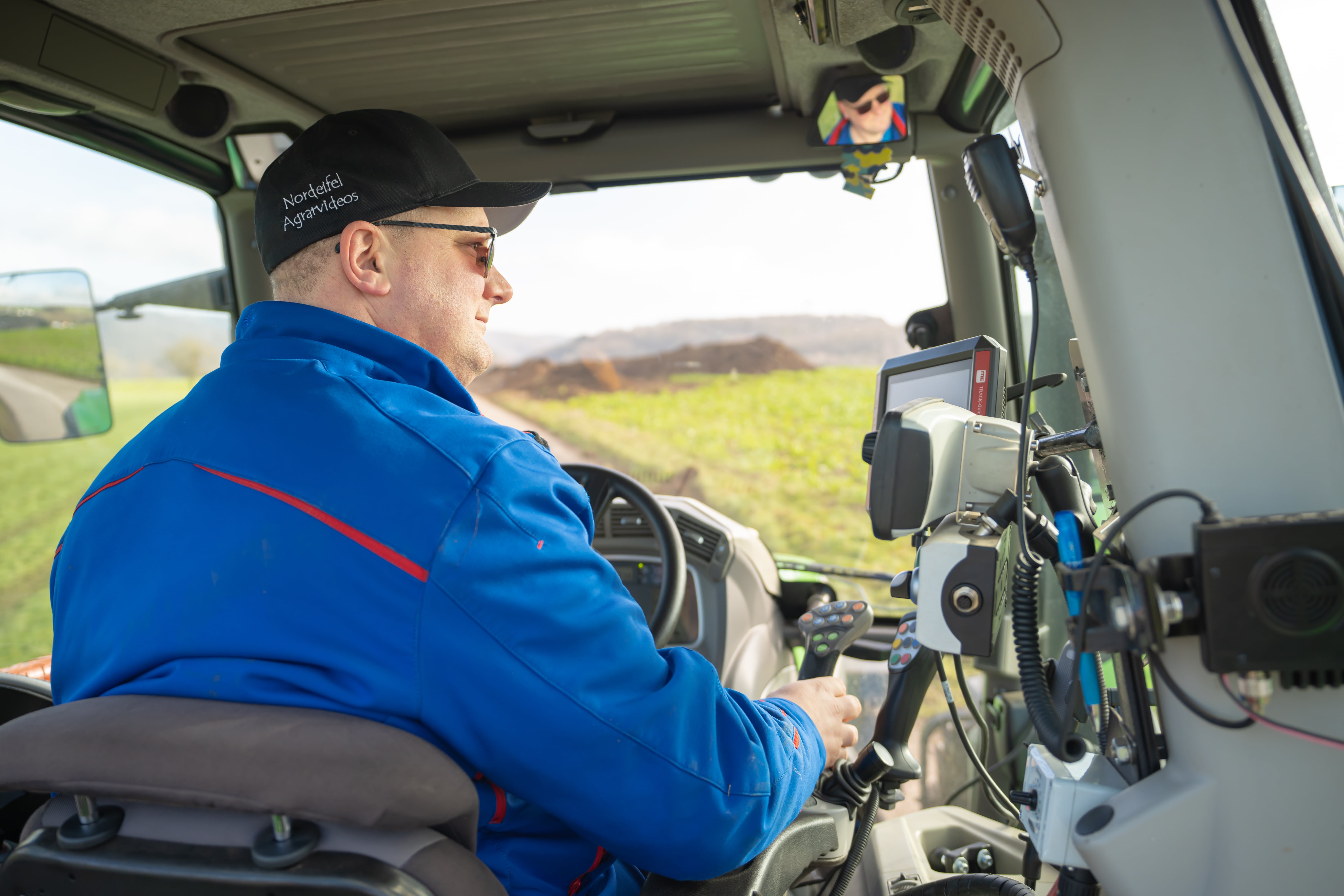 Landwirt im Traktor mit digitalen Tools